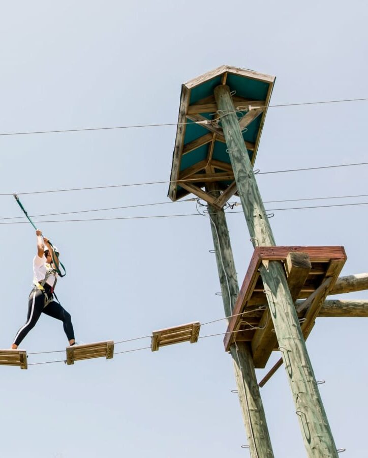 person walking across towers on planks