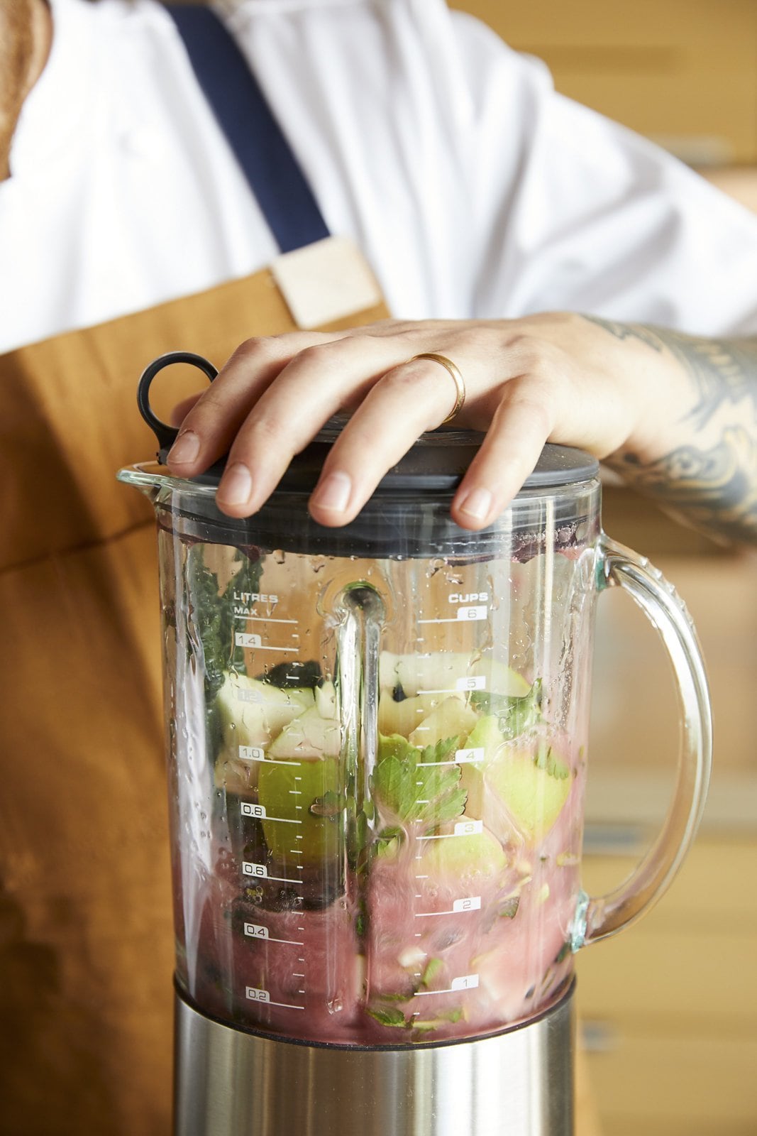 person holding down lid of blender