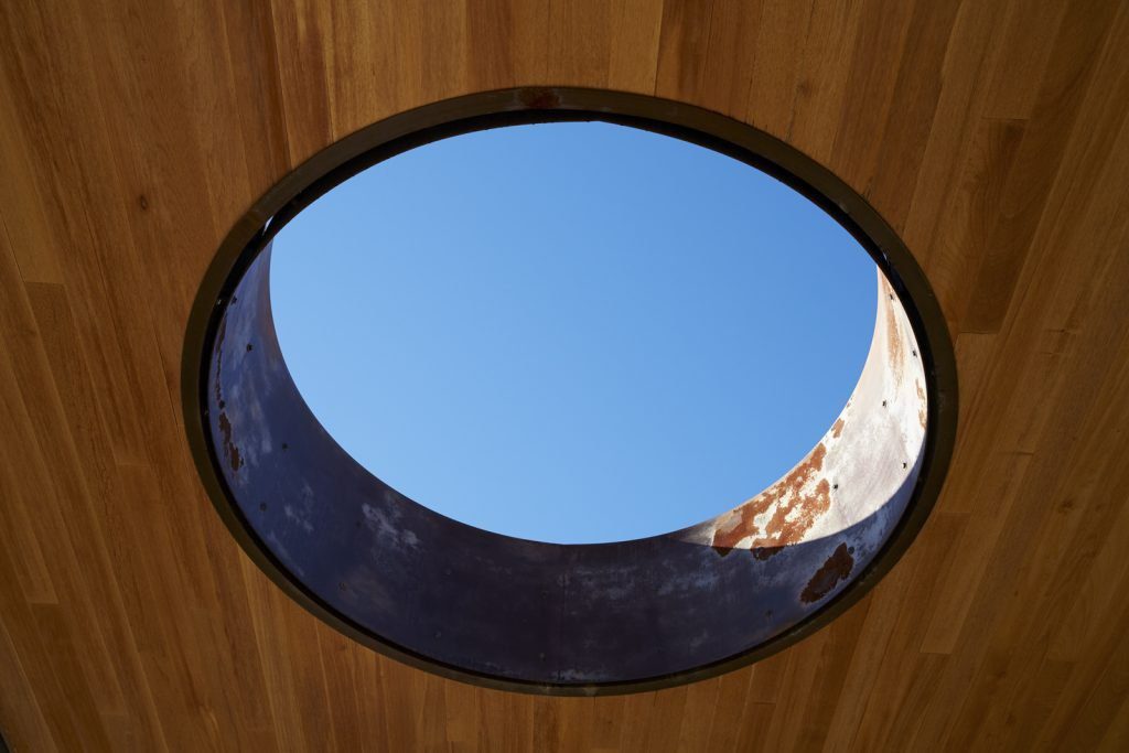 Skylight in wood ceiling with view into blue sky