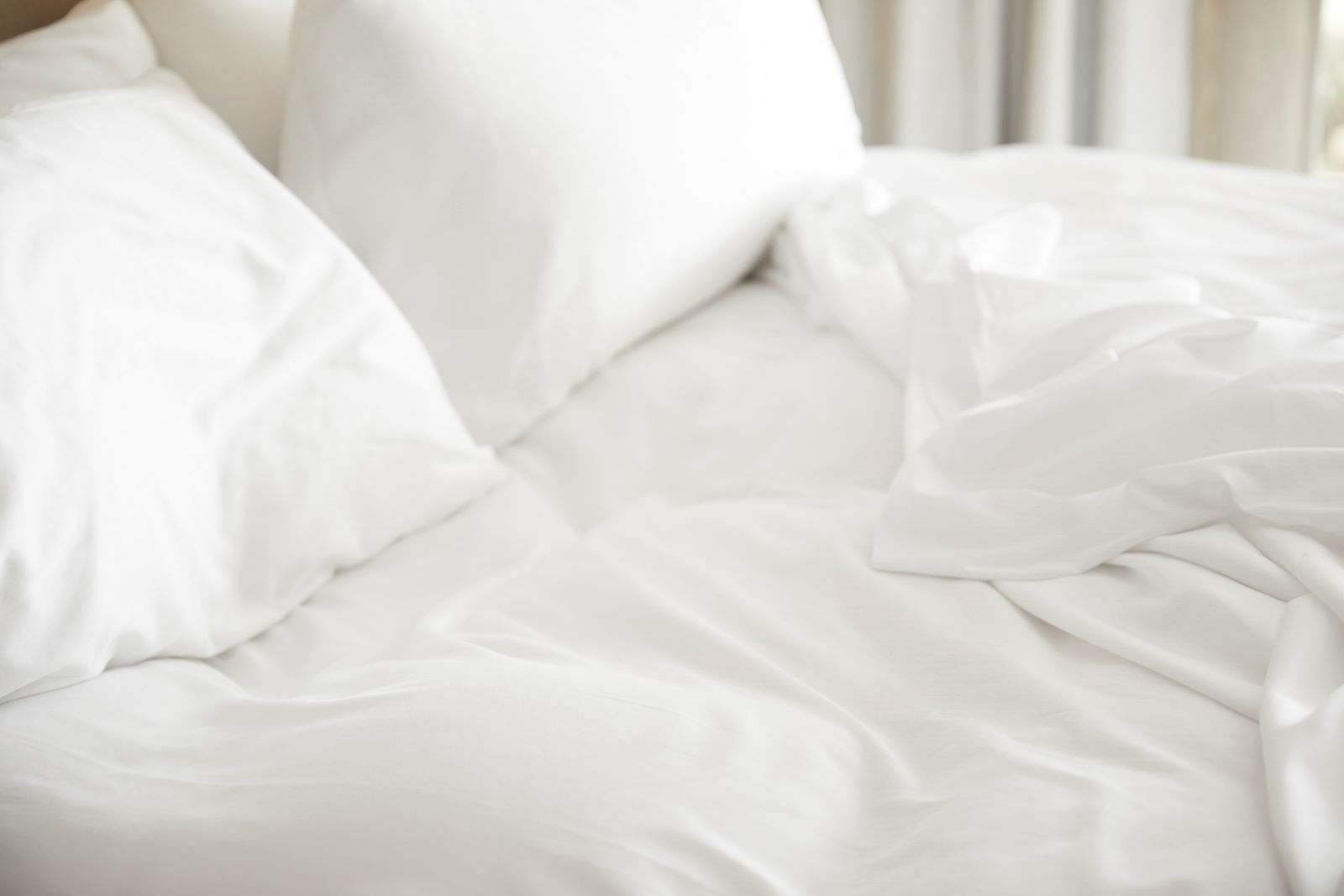 White pillows and blanket on queen bed