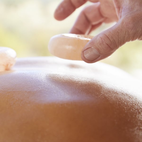 hand placing stones on back