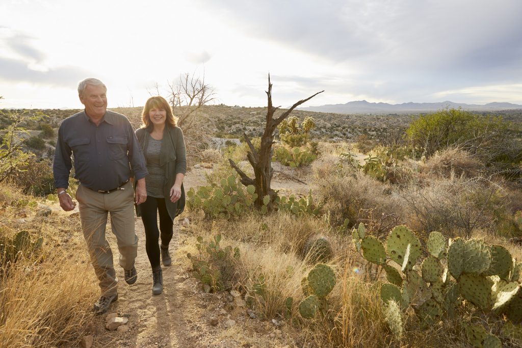 Smiling people walking on trail in desert