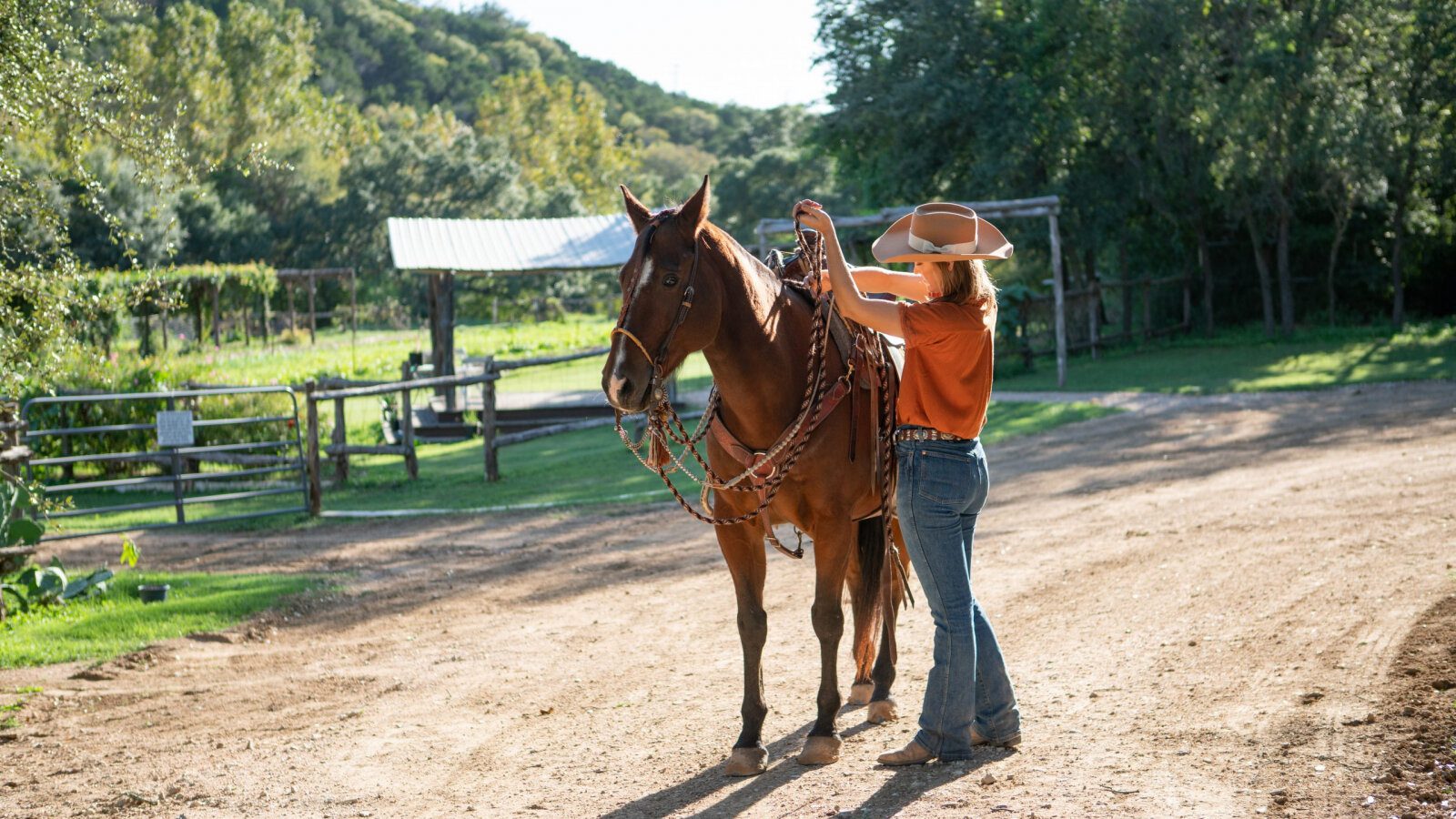 person saddling up a horse