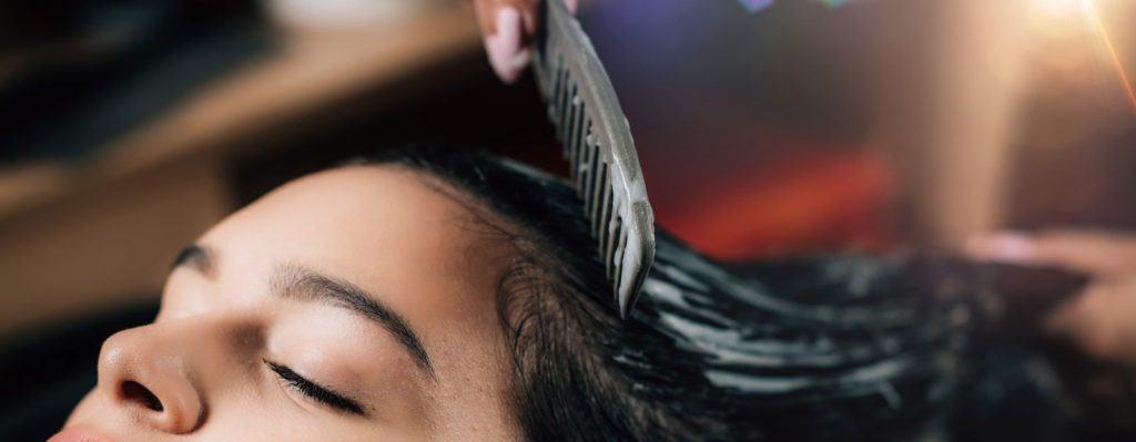 Woman brushing wet hair with comb