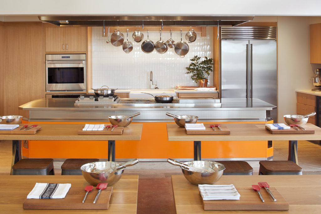 Kitchen for cooking class with counter and pants and table for students with mixing bows and baking utensils