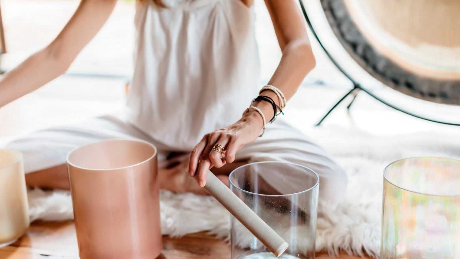 person holding a pipe beside sound bowls