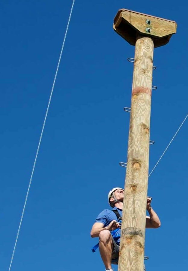 person climbing up a pole