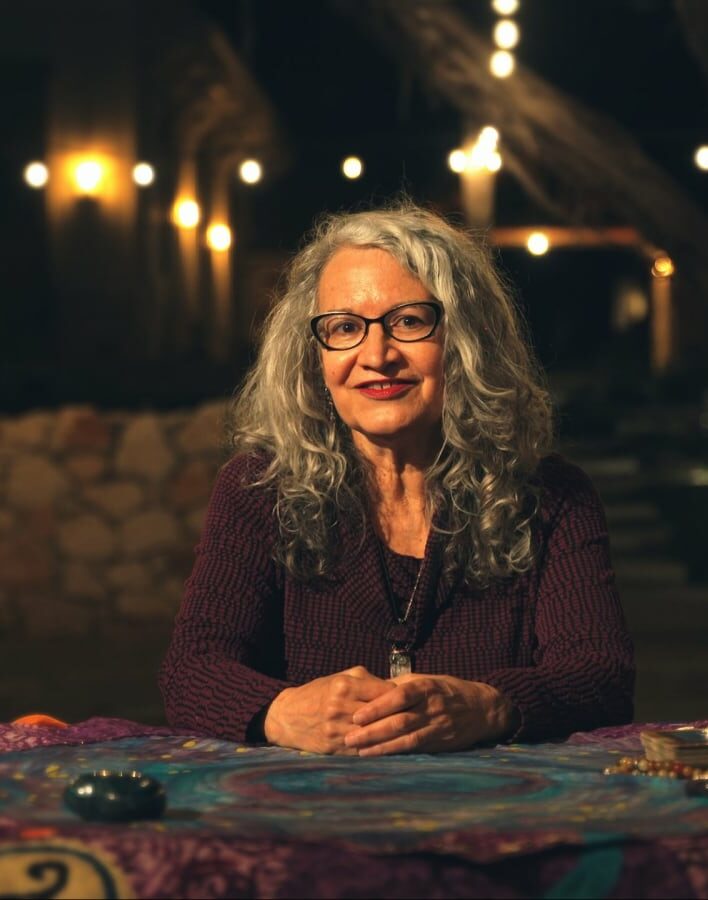 person at table with tarot cards