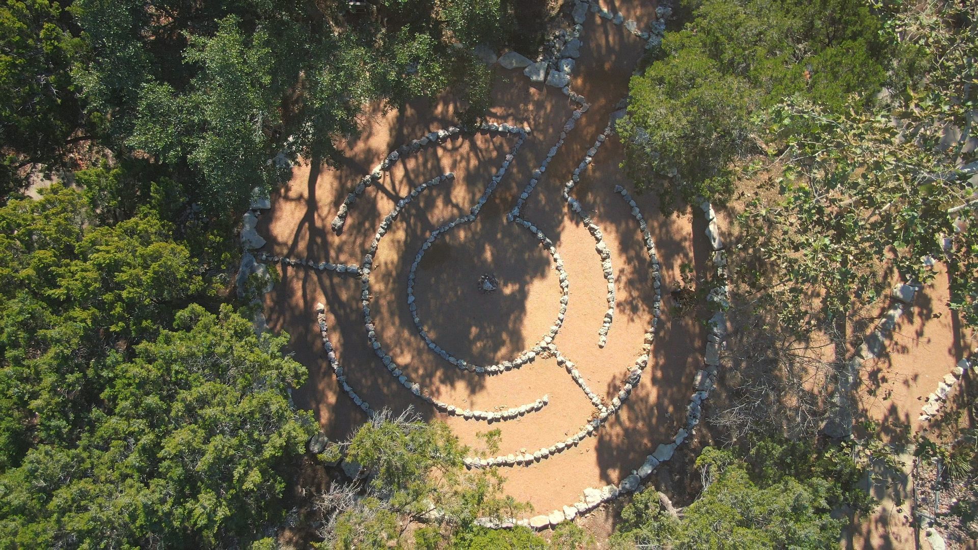 Aerial view of stone labyrinth in between trees