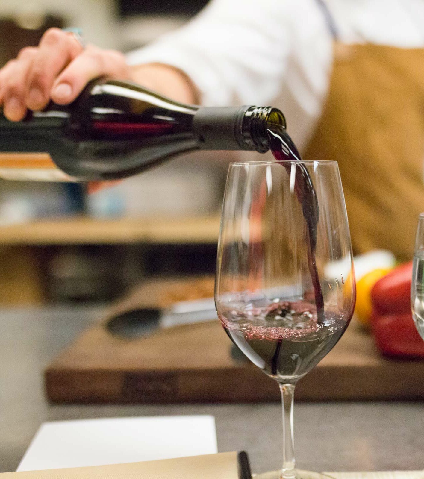 person pouring wine into a glass