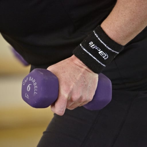 person's hand carrying a barbell